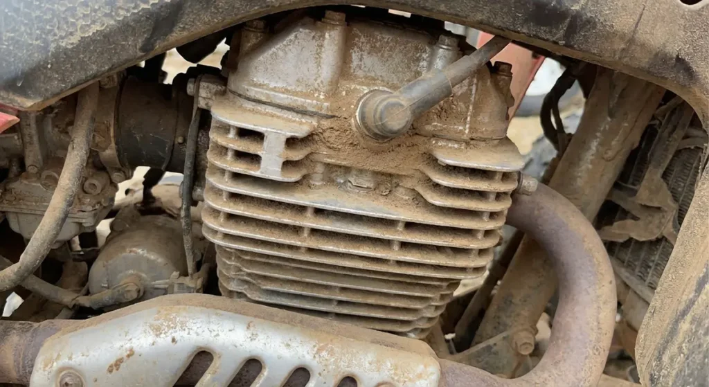 An old Honda TRX400EX engine showing the cooling fins covered in a light layer of dust