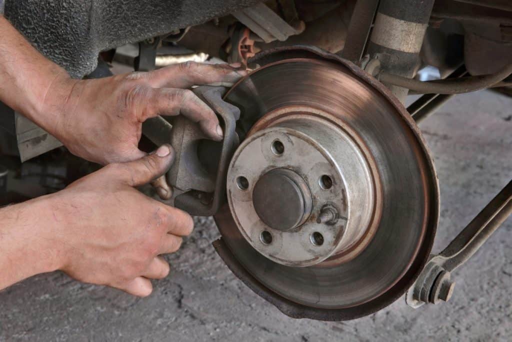 Car mechanic working on disc brakes